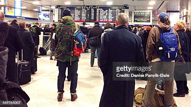 Commuters at NY Penn Station attentively watch the Big Board to see which track their trains will be leaving during the evening rush home.