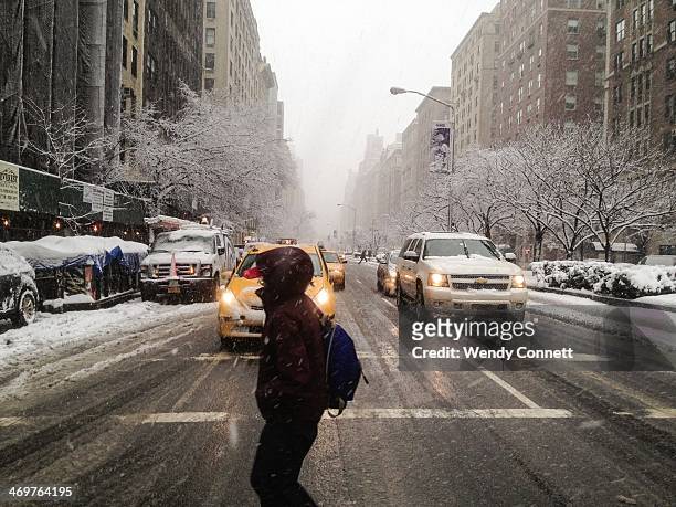 Pedestrian crosses Park Avenue on the Upper East Side of Manhattan during a snow storm on February 3 New York City, USA