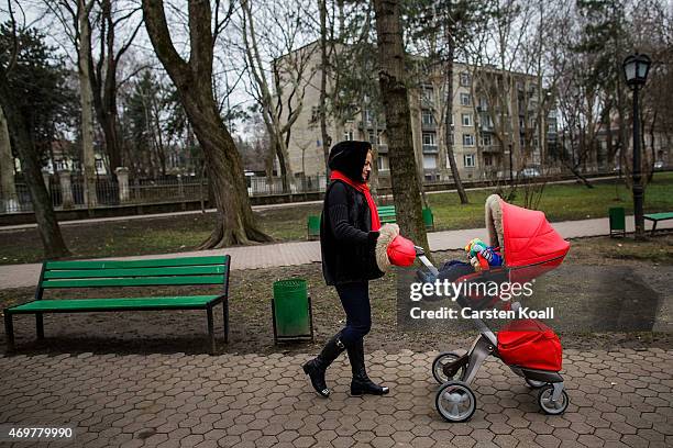Woman pushing a red pram in a city park on March 15, 2015 in Chisinau, Moldova. About 3.5 million inhabitants, the Republic of Moldova is a...