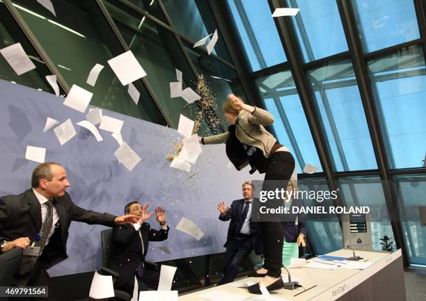 Woman jumped on the table throws papers and confetti as she interrupts a press conference by Mario Draghi , President of the European Central Bank,...