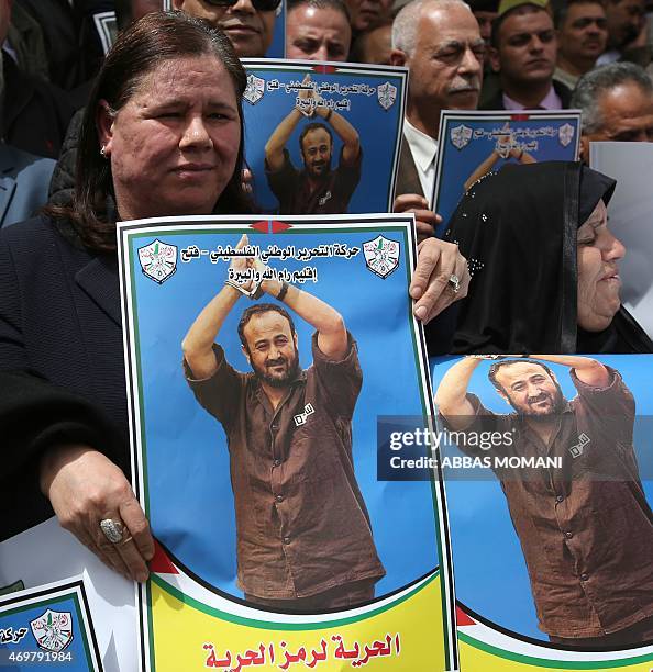 Fadwa Barghuti , the wife of jailed Palestinian Fatah leader Marwan Barghuti, holds a placard bearing his portrait, during a march to mark the...