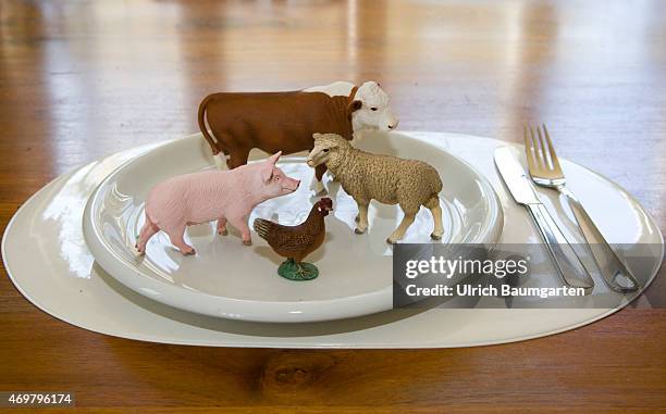 What we eat - Symbol photo on the topics of healthy living. Our picture shows a cow, a pig, a scheep and a chicken with plate and cutlery.