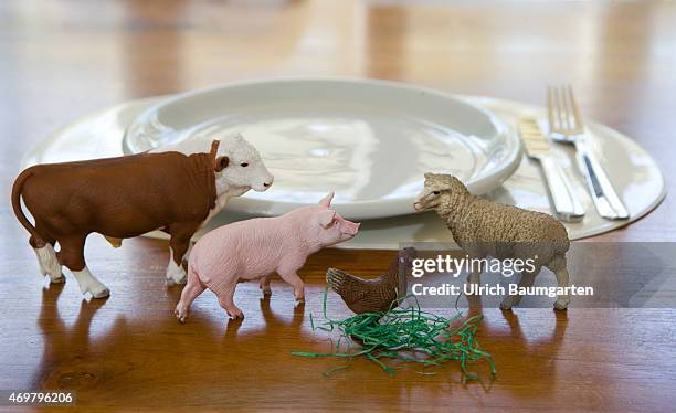 What we eat - Symbol photo on the topics of healthy living. Our picture shows a cow, a pig, a scheep and a chicken with plate and cutlery.