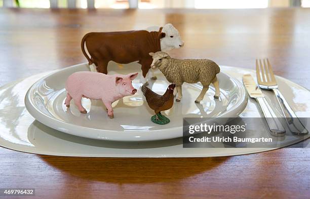 What we eat - Symbol photo on the topics of healthy living. Our picture shows a cow, a pig, a scheep and a chicken with plate and cutlery.