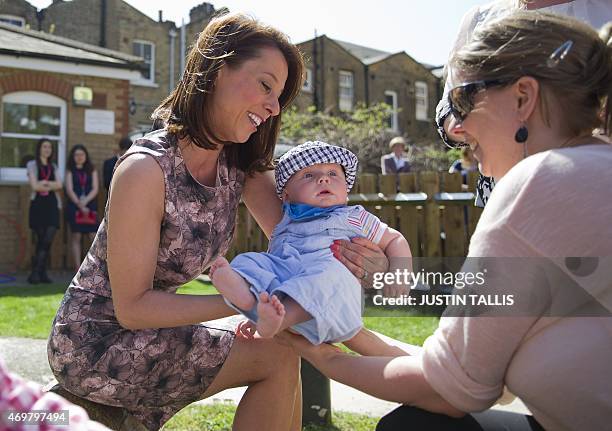 The Labour Party's prospective parliamentary candidate for Ashfield, Gloria De Piero, holds a baby during a visit to Stockwell Gardens Nursery on a...
