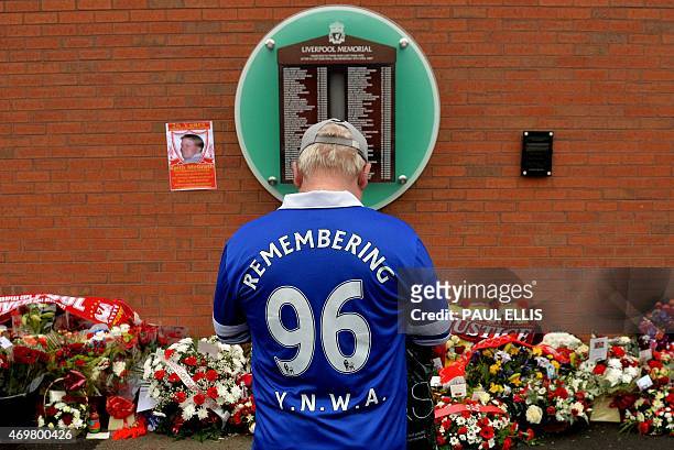 An Everton supporter stands in front of the temporary Hillsborough memorial, ahead of a memorial service at Anfield in Liverpool, north west Engand...