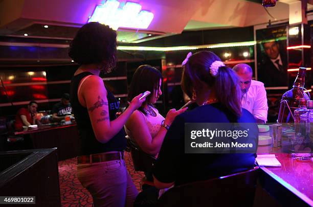 Young women await patrons of the Palestine Hotel's Panorama bar overlooking the Tigris River on April 13, 2015 in Baghdad, Iraq. Baghdad has again...