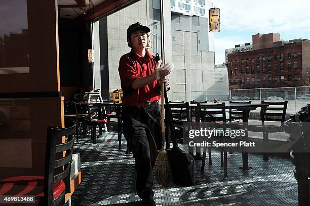 McDonald's employee is viewed working in a Brooklyn restaurant on the morning when thousands of people took to the street to demand a minimum wage of...