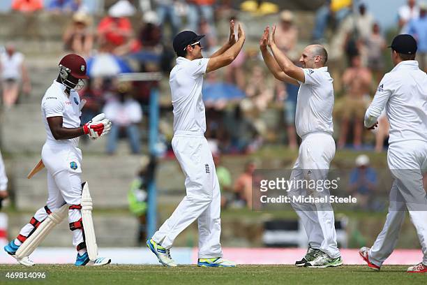 James Tredwell of England receives the congratulations from Alastair Cook after claiminge the wicket of Kemar Roach of West Indies during day three...