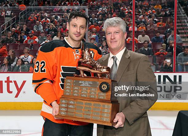 Mark Streit of the Philadelphia Flyers is presented with the Barry Ashbee Throphy by Barry's son Danny for the team's outstanding defenseman prior to...