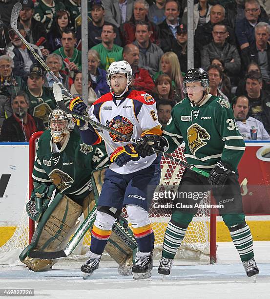 Jake Marchment of the Erie Otters skates between Michael Giugovaz and Julius Bergman of the London Knights during Game Four of the OHL Western...