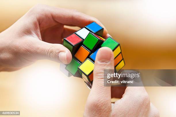 hands playing a cube game - solving rubix cube stock pictures, royalty-free photos & images