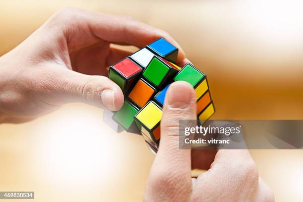 hands playing a cube game - rubics cube stock pictures, royalty-free photos & images