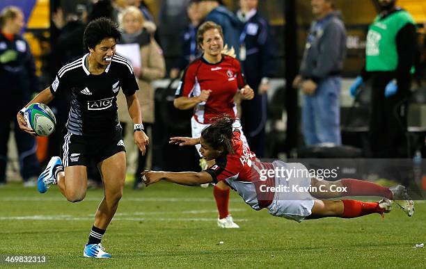 Gayle Broughton of New Zealand breaks a tackle by Magali Harvey of Canada on her way to scoring a try during the Women's Sevens World Series at Fifth...