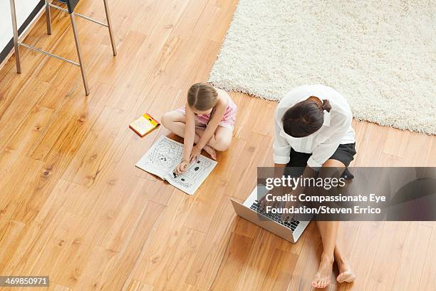 mother and girl (6-7) on floor in living room - mini jupe photos et images de collection