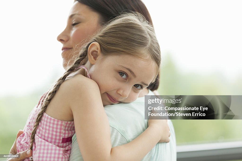 Close up of daughter hugging mother