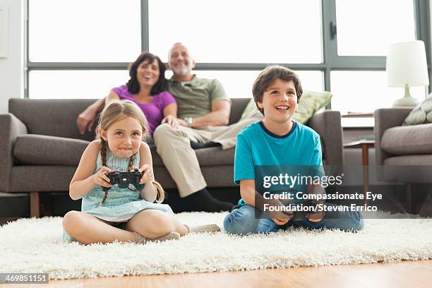 multi-generation family relaxing in living room - game four stockfoto's en -beelden