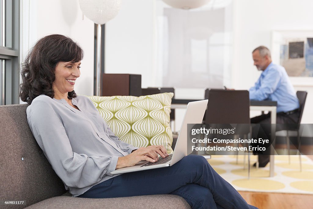 Mature woman on sofa using laptop