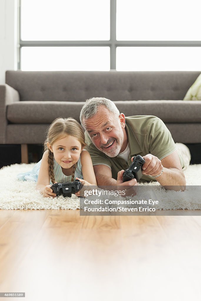 Grandfather and granddaughter playing video games