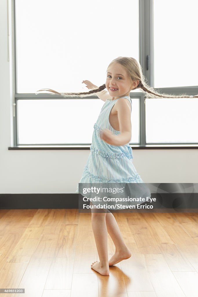 Girl (6-7) spinning indoors