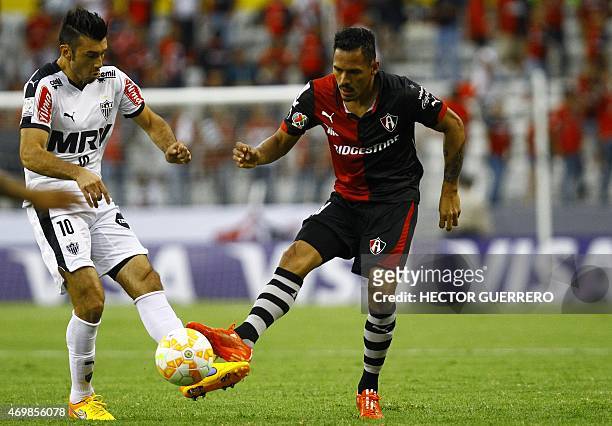 Aldo Leao of Atlas of Mexico vies for the ball with Jesus Datolo of Atletico Mineiro of Brazil during their Libertadores Cup football match at...