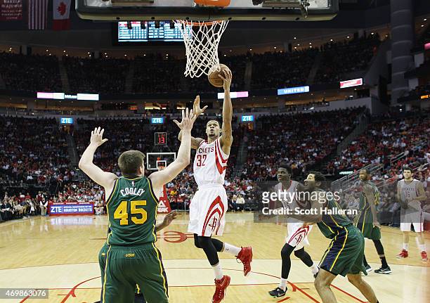 McDaniels of the Houston Rockets takes the ball to the basket against Jack Cooley and Grant Jerrett of the Utah Jazz during their game at the Toyota...