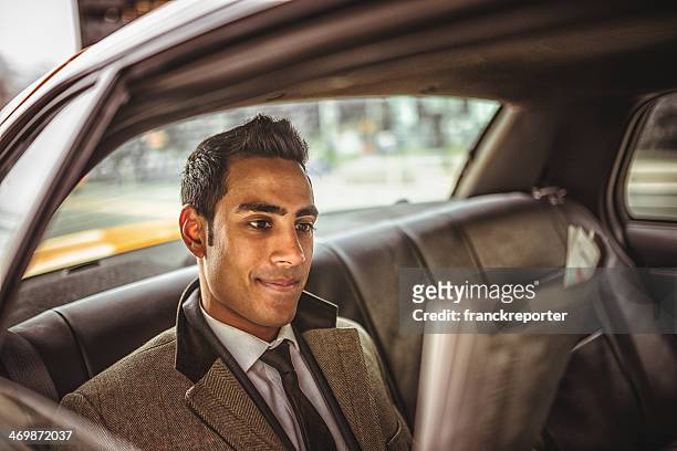 businessman on a taxi cab reading newspaper - man in car reading newspaper stock pictures, royalty-free photos & images