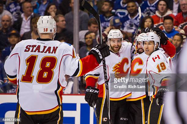 David Jones of the Calgary Flames is congratulated by T.J. Brodie, Michael Ferland and Matt Stajan after scoring a goal against the Vancouver Canucks...