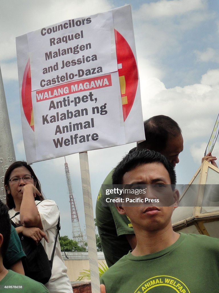 A Filipino protester holds a placard assailing councilors...