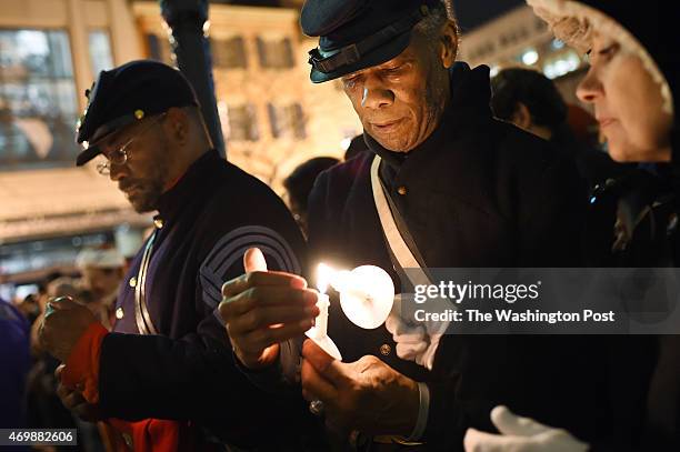 Louis Carter, left, Bernie Siler, center, and others gather outside Ford's Theatre in remembrance of the 150th anniversary of President Abraham...