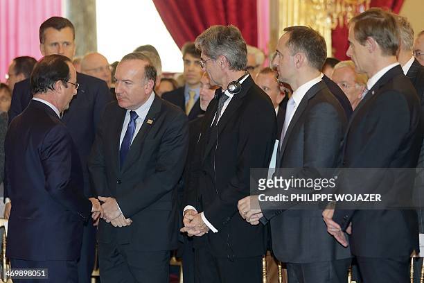 French President Francois Hollande speaks with President of French employers' Medef association Pierre Gattaz , flanked by President and CEO of...