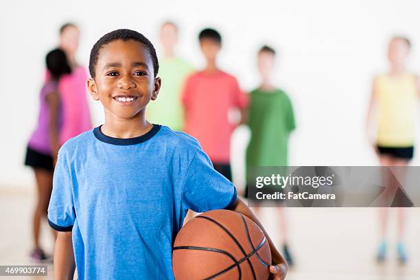 little boy holding a basketball - elementary basketball stock pictures, royalty-free photos & images