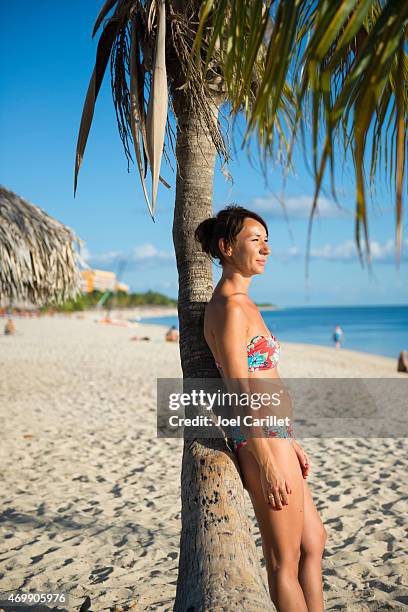 frau besuch in kuba schiefen gegen palme am playa ancon - kuba strand stock-fotos und bilder