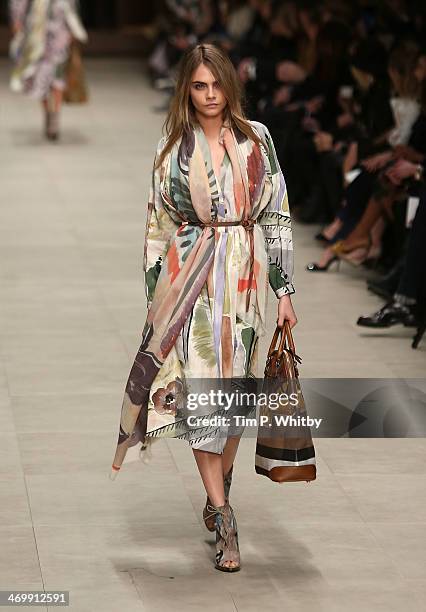 Model Cara Delevingne walks the runway at the Burberry Prorsum show at London Fashion Week AW14 at Perks Fields, Kensington Gardens on February 17,...