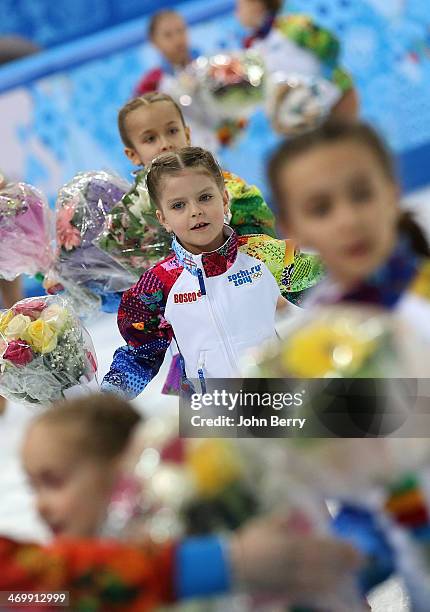 Flower girls pick up bouquets after Daisuke Takahashi of Japan performed in the Figure Skating Men's Free Skating on day seven of the Sochi 2014...