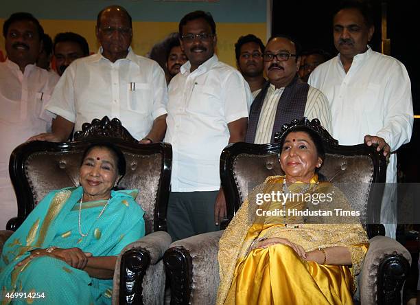 Legendary singer Asha Bhosle poses with her wax statute as NCP Chief Sharad Pawar looks on during the unveiling of their wax models at the MCA lounge...