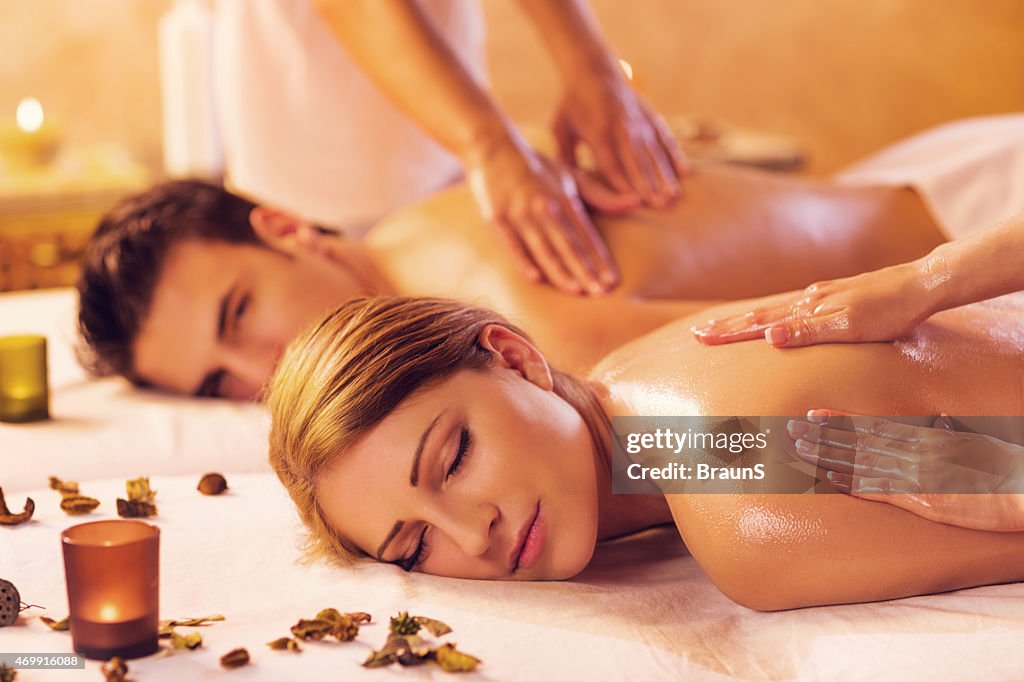 Jeune couple se détendre lors d'un massage du dos au spa.