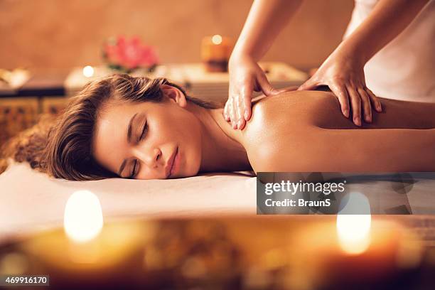 jovem mulher relaxante durante a massagem no spa de trás. - spa treatment imagens e fotografias de stock