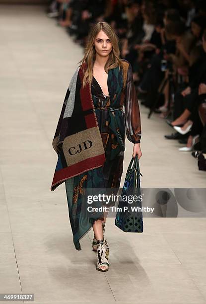 Model Cara Delevingne walks the runway at the Burberry Prorsum show at London Fashion Week AW14 at Perks Fields, Kensington Gardens on February 17,...