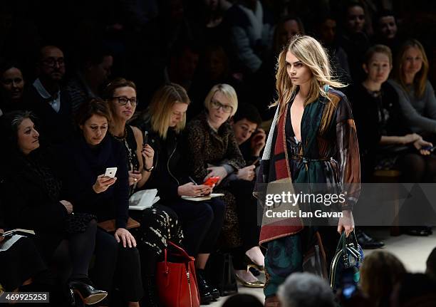 Cara Delevingne walks the runway at Burberry Womenswear Autumn/Winter 2014 at Kensington Gardens on February 17, 2014 in London, England.