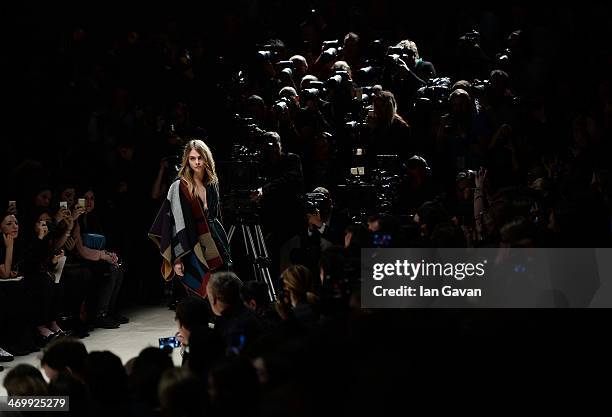 Cara Delevingne walks the runway at Burberry Womenswear Autumn/Winter 2014 at Kensington Gardens on February 17, 2014 in London, England.