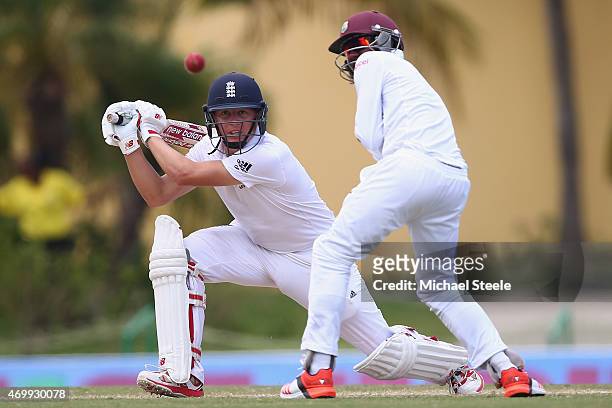 Gary Ballance of England plays through the covers as Jermaine Blackwood fields in close during day four of the 1st Test match between West Indies and...