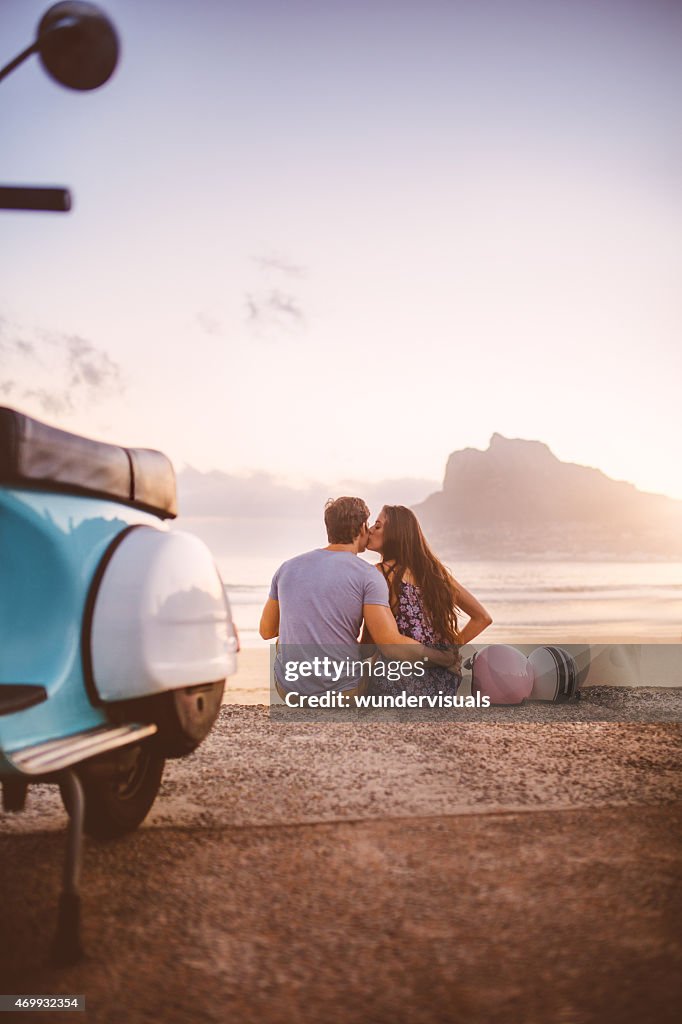 Couple at the beach with scooter on a road trip