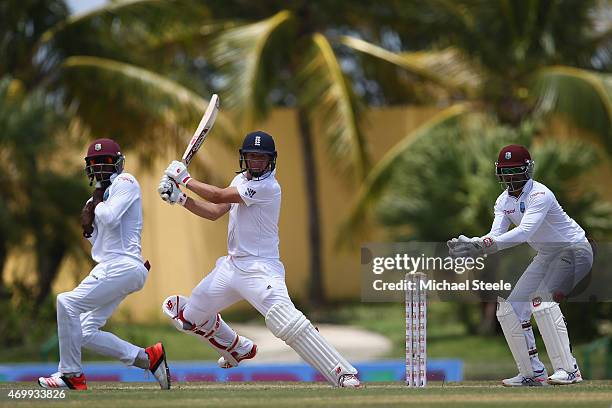 Gary Ballance of England plays to the offside as wicketkeeper Denesh Ramdin and Jermaine Blackwood look on during day four of the 1st Test match...