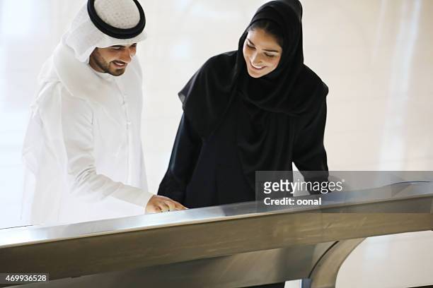 arab family using interactive screen of digital kiosk - bahrain people stock pictures, royalty-free photos & images