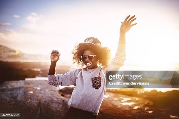 fun african american girl laughing and dancing at the beach - african girls on beach stockfoto's en -beelden