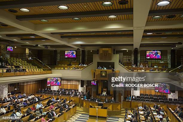 Television screens in the South African Parliament show members of opposition Economic Freedom Fighters trying to get South African President, Jacob...