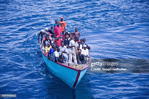 afrikaner in ein überladenes boot - sénégal migration stock-fotos und bilder