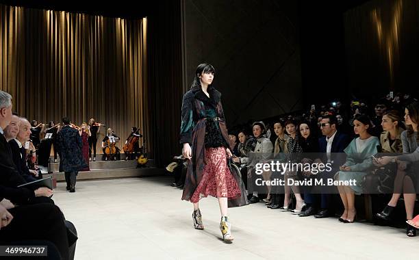 Paloma Faith performs as model Edie Campbell walks the runway at Burberry Womenswear Autumn/Winter 2014 at Kensington Gardens on February 17, 2014 in...