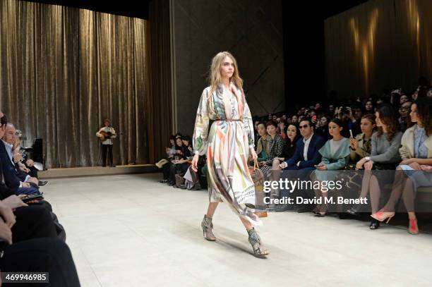 Cara Delevingne walks the runway at Burberry Womenswear Autumn/Winter 2014 at Kensington Gardens on February 17, 2014 in London, England.